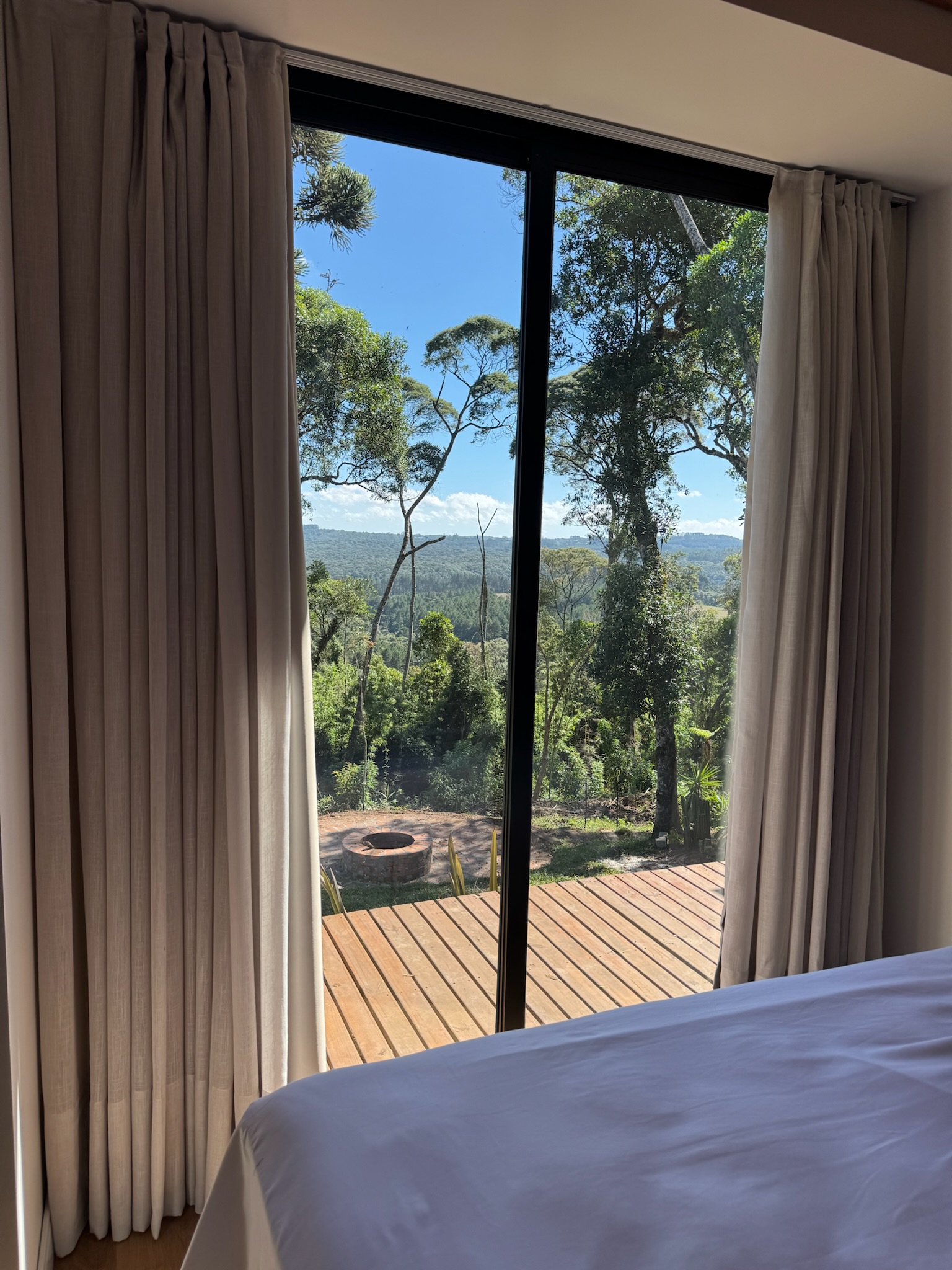 Quarto com vista para o deck e natureza