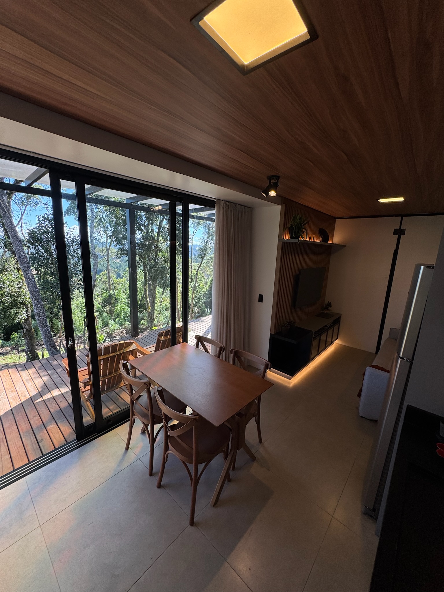 Sala com janela panorâmica para o deck