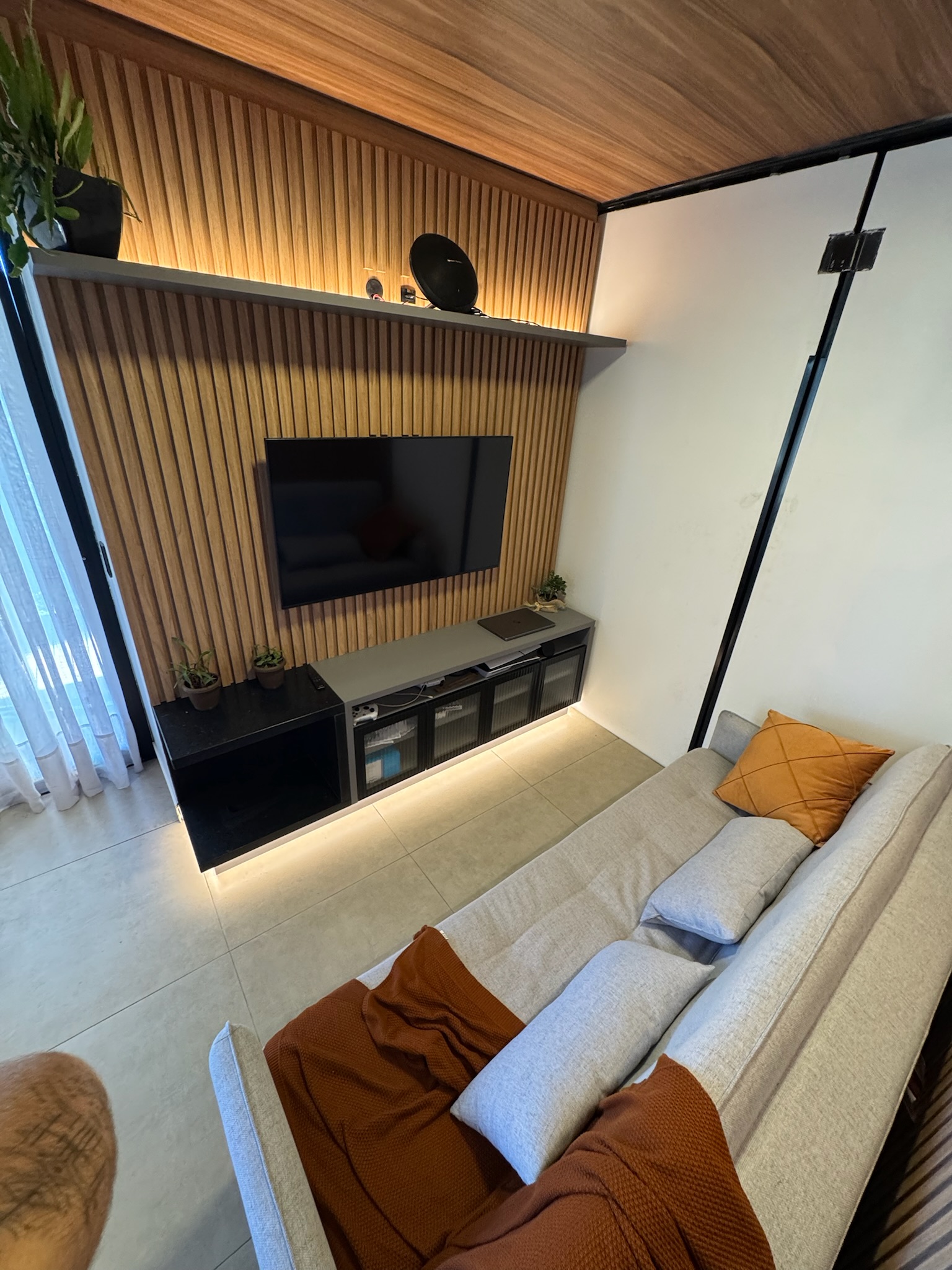 Sala com painel ripado e TV